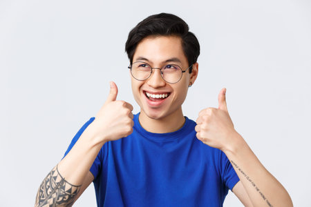 Lifestyle, people emotions and beauty concept. Enthusiastic happy asian man in glasses, smiling...