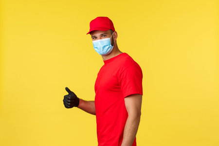 Express delivery during pandemic, covid-19, safe shipping, online shopping concept. Smiling handsome...