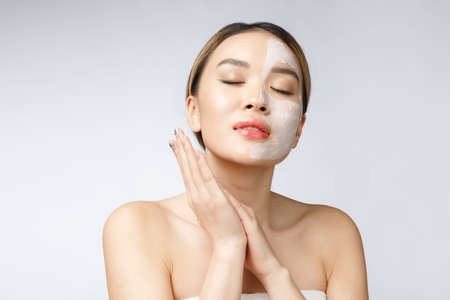 Charming pleasant woman applying cream on half face.の写真素材
