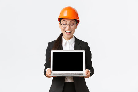 Impressed happy asian female chief engineer showing great results of enterprise to investors,...