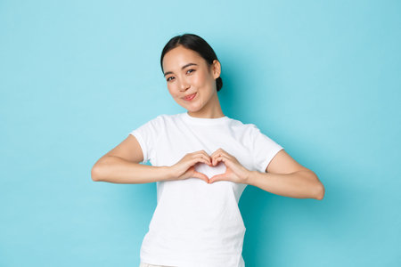 Lovely asian girl in white t-shirt showing sympathy, express care and tender feelings towards...