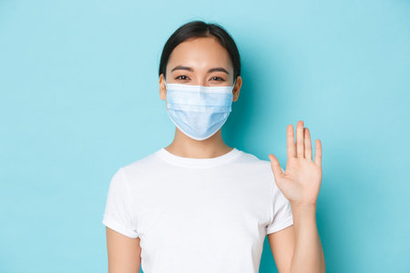 Covid-19, social distancing and coronavirus pandemic concept. Close-up of cheerful, friendly asian...