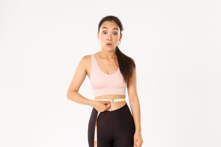 Fitness, healthy lifestyle and wellbeing concept. Surprised asian girl on diet, sportswoman wrap...