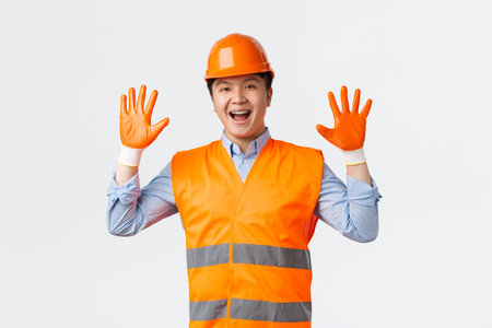 Building sector and industrial workers concept. Cheerful smiling asian builder, construction manager...