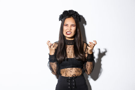 Image of angry wicked witch cursing and swearing, clenching fists and grimacing with hatred,...