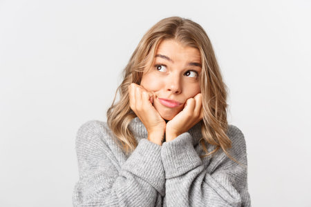 Close-up of attractive silly female model with blond short hairstyle, looking at upper left corner...