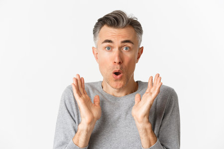 Close-up of surprised, handsome middle-aged man, saying wow and looking at cool promo offer,...