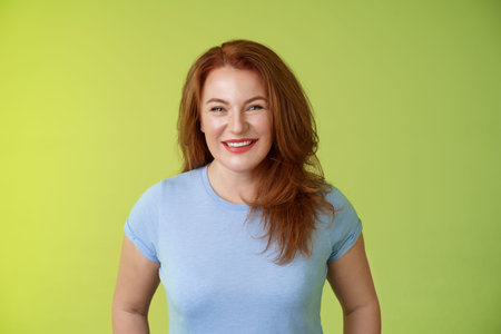 Cheerful kind happy redhead middle-aged mother look caring delighted smiling broadly gaze admiration...