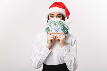 Christmas and finance concept - Young business woman showing money closing her face with surprise expression.の写真素材