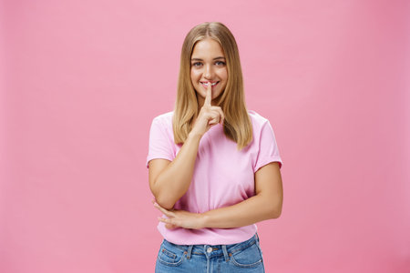Shh keep it secret. Portrait of charismatic cheerful chubby girl with tanned skin and fair hair...
