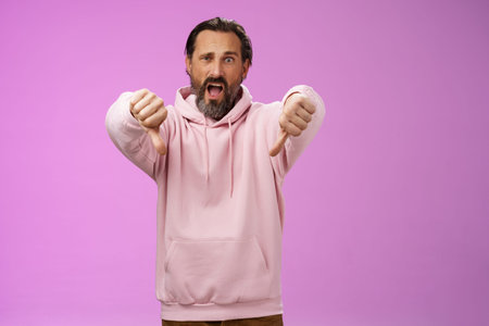 Extremely disappointed furious male customer swearing show thumbs down impulsive gesture yelling...