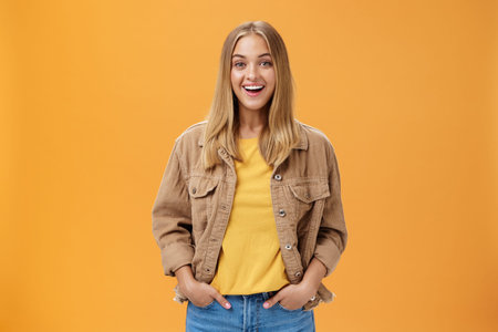 Charismatic tanned woman in corduroy jacket and yellow t-shirt ready for chilly autumn walk with...