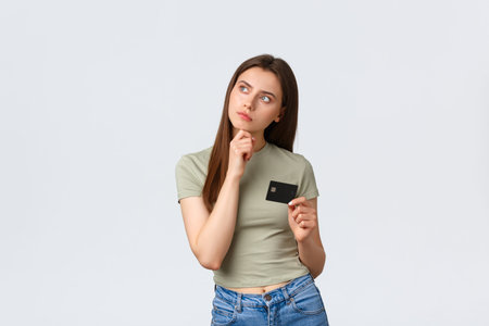 Shopping mall, lifestyle and fashion concept. Thoughtful pleased woman thinking what buy for money...