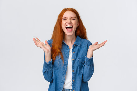 Lol so funny. Amused and carefree pretty redhead female student clap hands, applause with closed eyes as laughing out loud, having fun, hear hilarious joke, standing white backgroundの写真素材