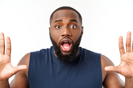 Young fitness african black man in sport wear cheering carefree isolated over white background.の写真素材