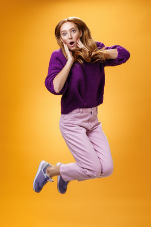 Impressed and surprised amazed good-looking redhead female in purple sweater open mouth astonished...