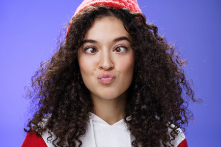 Headshot of funny and playful girl fooling around making faces not scared being funny folding lips...