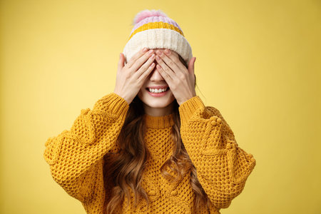 Close-up studio shot charming cute young girl waiting surprise press palms eyes smiling anticipating secret present, standing amused cannot wait gaze awesome gift, birthday party conceptの写真素材