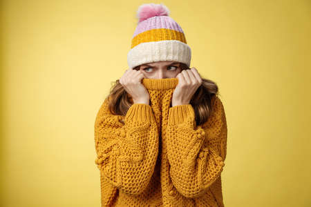 Offended sad whining cute tender young girl hiding face pull sweater nose peek look aside insulted complaining being insulted, standing miserable upset wearing warm winter corduroy hatの写真素材