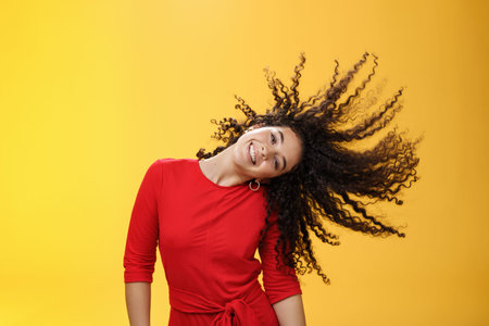 Girl getting carefree and wild waving hair and making sun with curls flying in air smiling broadly...