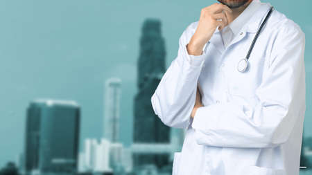 Portrait Of Young Male Doctor Wearing Scrubs Standing In Modern Hospital Building.の写真素材