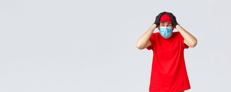 Covid-19, self-quarantine, online shopping and shipping concept. Troubled and anxious delivery guy...