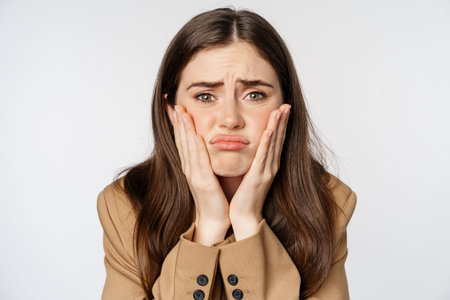 Image of sad girl looking in mirror and touching facial skin, shocked and frustrated over bad skin...