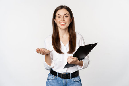 Corporate woman, businesswoman holding clipboard with documents in office, smiling at camera, white...