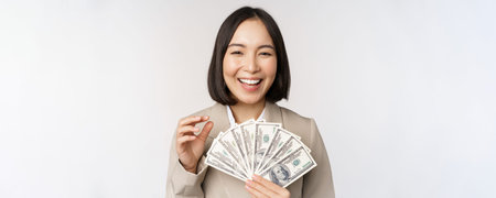 Image of successful businesswoman holding money. Asian corporate woman with cash dollars, smiling...