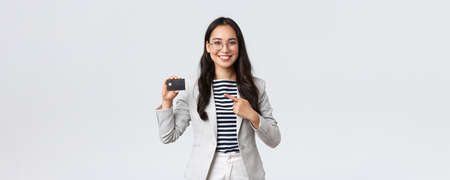 Business, finance and employment, entrepreneur and money concept. Professional female bank clerk, office manager recommend credit card, banking service, pointing at it confidentの写真素材