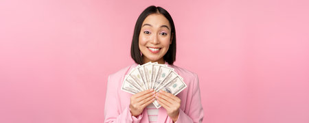 Finance, microcredit and people concept. Happy smiling asian businesswoman showing dollars money,...