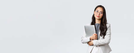 Business, finance and employment, female successful entrepreneurs concept. Young asian businesswoman, bank clerk in glasses holding laptop and looking cameraの写真素材