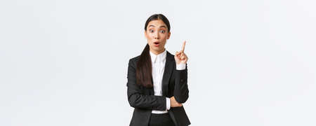 Astounded smart asian female entrepreneur, construction manager have great plan, raising finger up to suggest solution, sharing thoughts and ideas with group, standing white backgroundの写真素材