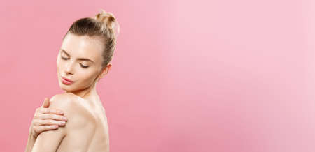 Beauty Concept - Beautiful Caucasian woman with clean skin, natural make-up isolated on bright pink background with copy space.の写真素材