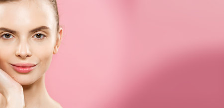 Beauty Concept - Close up Portrait of attractive caucasian girl with beauty natural skin isolated on pink background with copy space.の写真素材