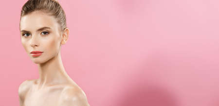 Beauty Concept - Beautiful Woman with Clean Fresh Skin close up on pink studio. Skin care face. Cosmetology.の写真素材