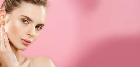 Beauty Concept - Beautiful Woman with Clean Fresh Skin close up on pink studio. Skin care face. Cosmetology.の写真素材