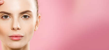 Beauty Concept - Close up Portrait of attractive caucasian girl with beauty natural skin isolated on pink background with copy space.の写真素材