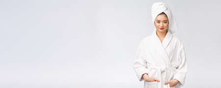 Portrait of a young happy asian lady in bathrobe.Isolated in white background.の写真素材