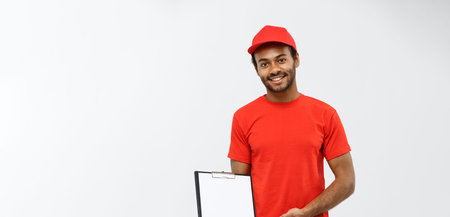 Delivery Concept - Portrait of Handsome African American delivery man or courier showing a...