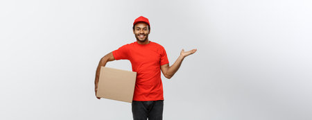 Delivery Concept - Portrait of Happy African American delivery man pointing hand to present a box...