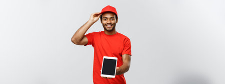 Delivery Concept - Portrait of Handsome African American delivery man or courier showing tablet on...