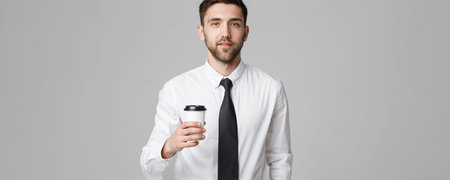 Portrait of a handsome businessman in formal suit with a cup of coffee.