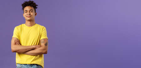 Close-up portrait of arrogant, proud and boastful young smart guy cross hands over chest in confident, self-assured pose, smirk and look mighty, feel like he knows everything, purple backgroundの写真素材