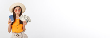 Portrait of cheerful, happy, laughing girl with hat on head, having money fan and passport with tickets in hands, isolated on white backgroundの写真素材