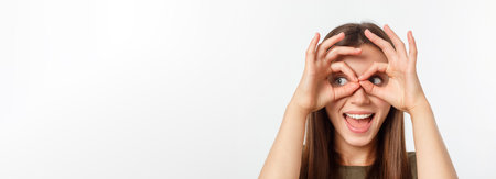 Close up portrait of cheerful, cute, stylish,attractive, trendy girl making binoculars with fingers,...