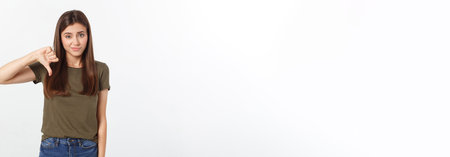 Image of resentful woman with long dark hair showing thumbs down isolated over gray background.の写真素材