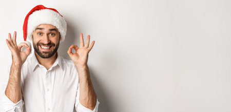 Party, winter holidays and celebration concept. Joyful man enjoying christmas and showing okay sign,...