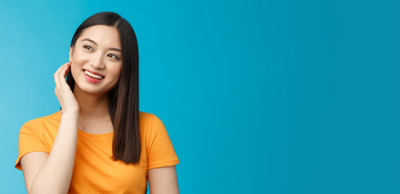 Tender lovely coquettish modern asian woman touch hair lovely look aside, smiling joyfully, feel...