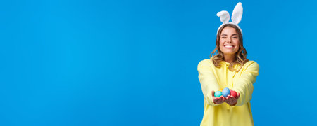 Holidays, people and emotions concept. Tender cute blond caucasian female giving Easter eggs to you...